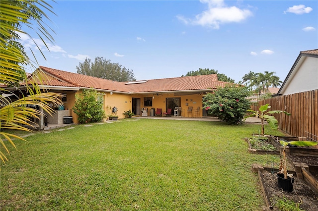 back of property with a patio area, ceiling fan, and a lawn