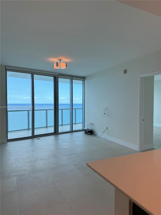 unfurnished living room featuring expansive windows and a water view