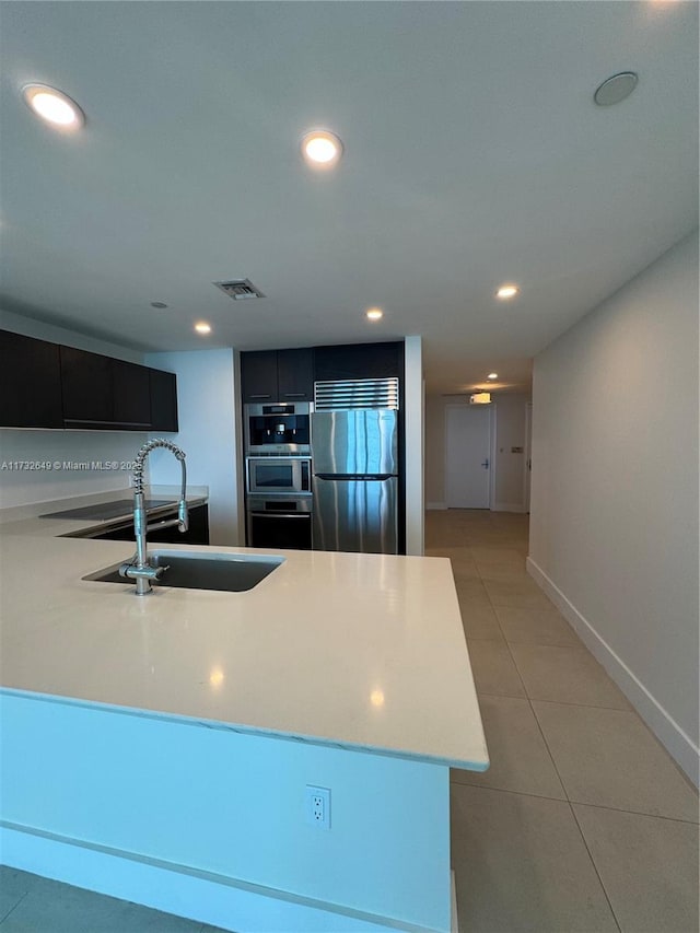 kitchen with sink, light tile patterned floors, and stainless steel appliances