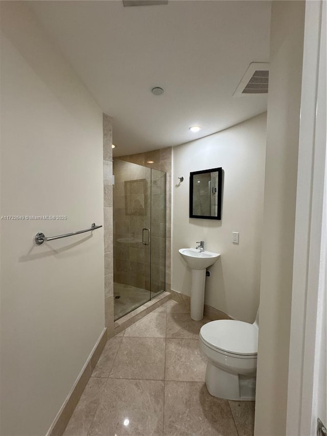 bathroom featuring sink, toilet, tile patterned flooring, and a shower with door