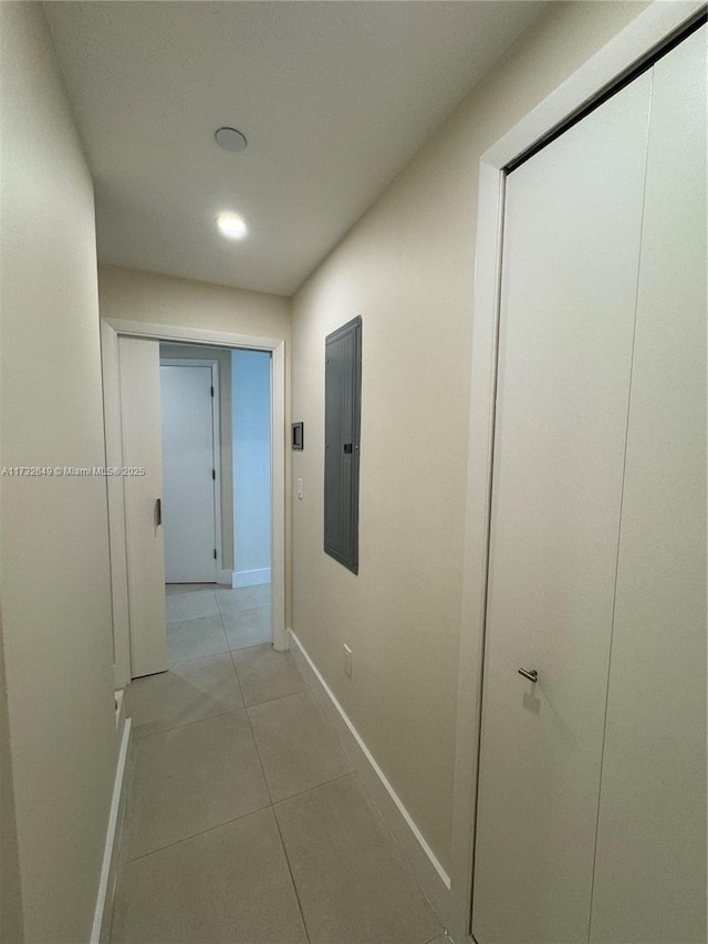 corridor with electric panel and light tile patterned flooring