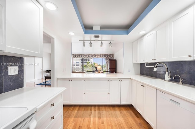 kitchen with white cabinetry, sink, backsplash, and light hardwood / wood-style floors