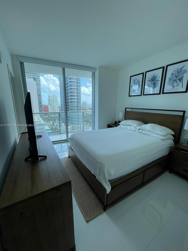 tiled bedroom with access to outside and floor to ceiling windows