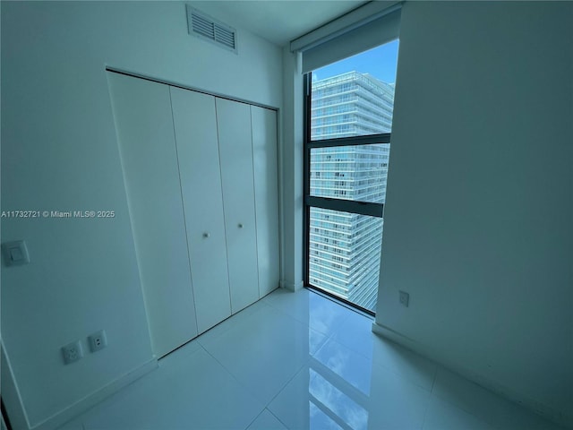 unfurnished bedroom featuring light tile patterned flooring and a closet