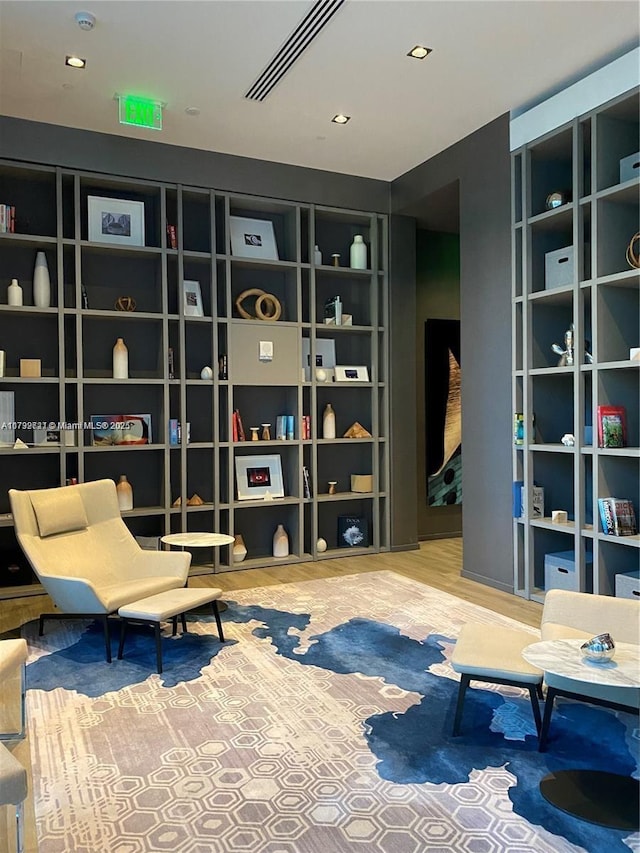 living area featuring built in shelves and wood-type flooring