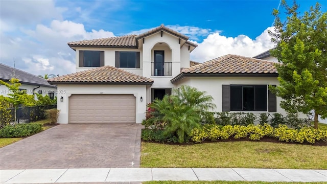 mediterranean / spanish-style house featuring a garage, a front lawn, and a balcony