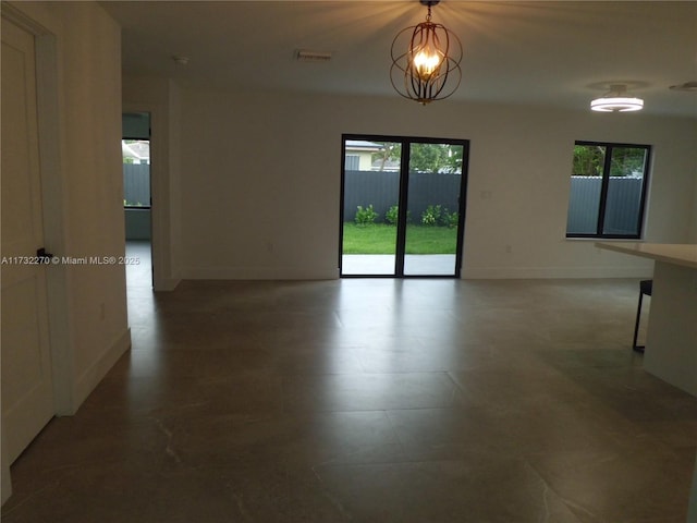 unfurnished room featuring a chandelier