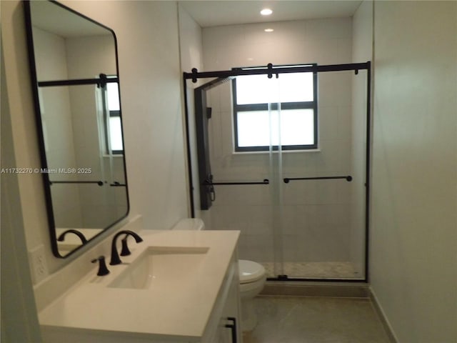 bathroom with toilet, vanity, and a shower with shower door