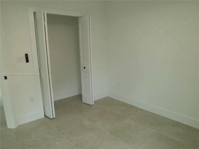 unfurnished bedroom featuring light tile patterned floors and a closet