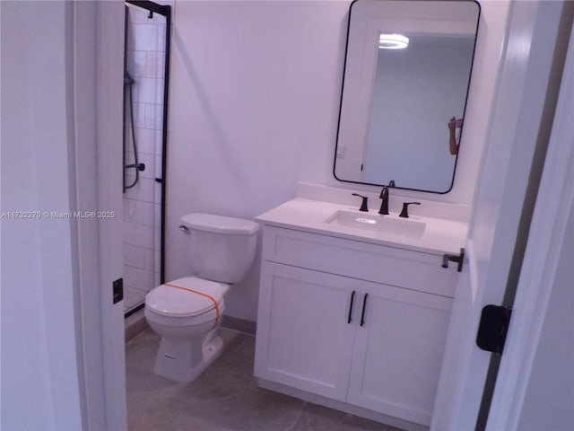 bathroom with vanity, tile patterned floors, toilet, and tiled shower