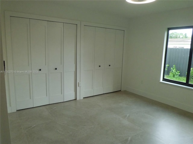 unfurnished bedroom featuring two closets