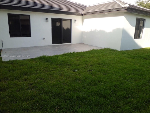 rear view of property with a yard and a patio area