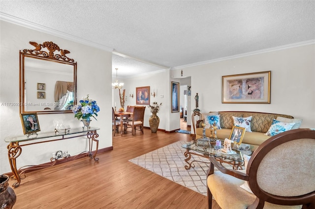 living room featuring hardwood / wood-style flooring, crown molding, a chandelier, and a textured ceiling