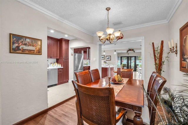 dining space with a notable chandelier, crown molding, light hardwood / wood-style flooring, and a textured ceiling