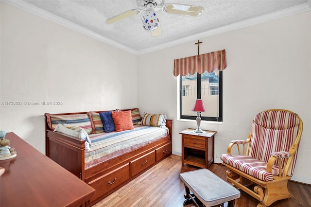 bedroom with crown molding, ceiling fan, wood-type flooring, and a textured ceiling