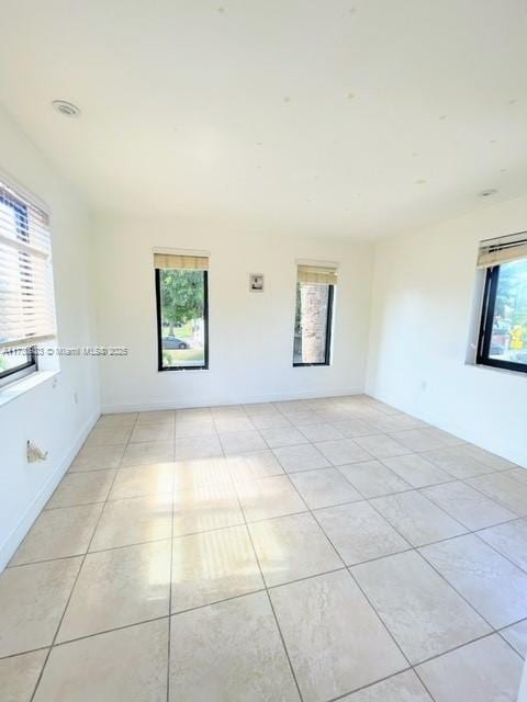 unfurnished room featuring light tile patterned flooring and a healthy amount of sunlight