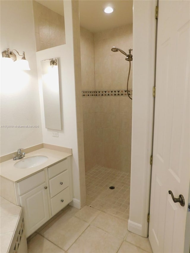 bathroom featuring tile patterned flooring, vanity, and tiled shower