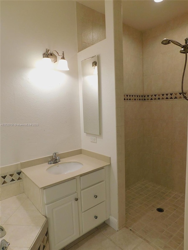 bathroom featuring tile patterned floors, vanity, and a tile shower