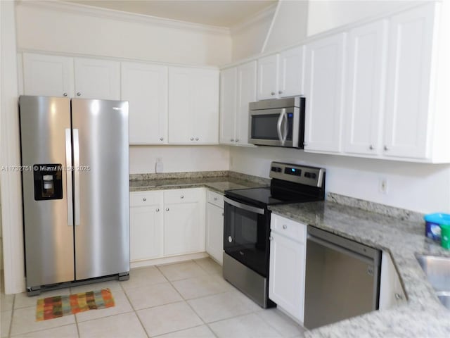 kitchen featuring light tile patterned flooring, stainless steel appliances, white cabinets, and stone countertops