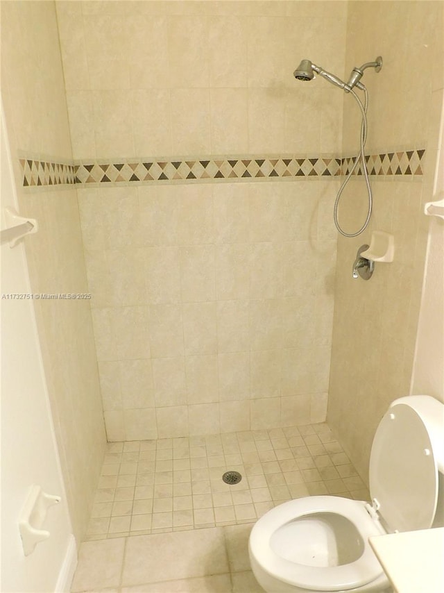 bathroom featuring tiled shower and toilet