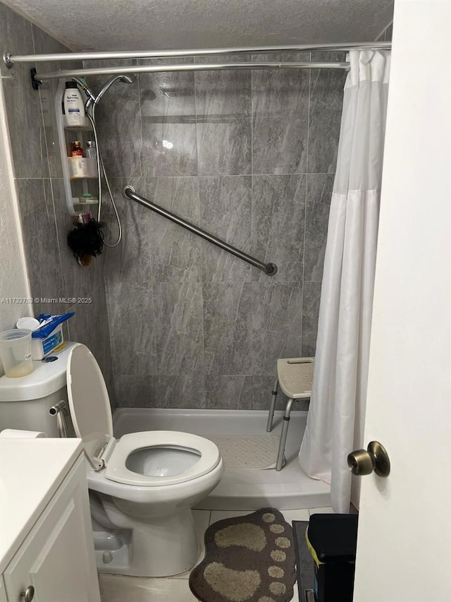 bathroom featuring tile patterned flooring, vanity, a textured ceiling, curtained shower, and toilet