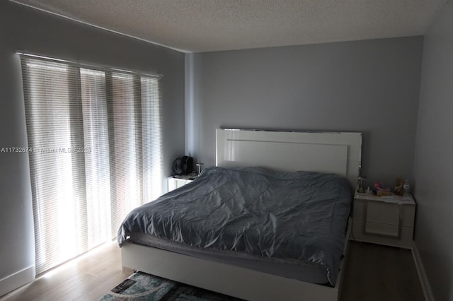 bedroom with wood-type flooring and a textured ceiling