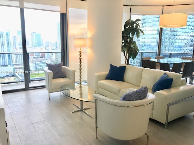 living room featuring floor to ceiling windows, a healthy amount of sunlight, and baseboard heating