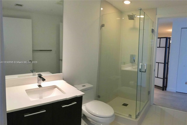 bathroom with an enclosed shower, vanity, tile patterned floors, and toilet