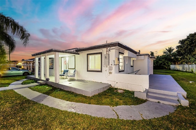 view of front of home with a patio area and a lawn