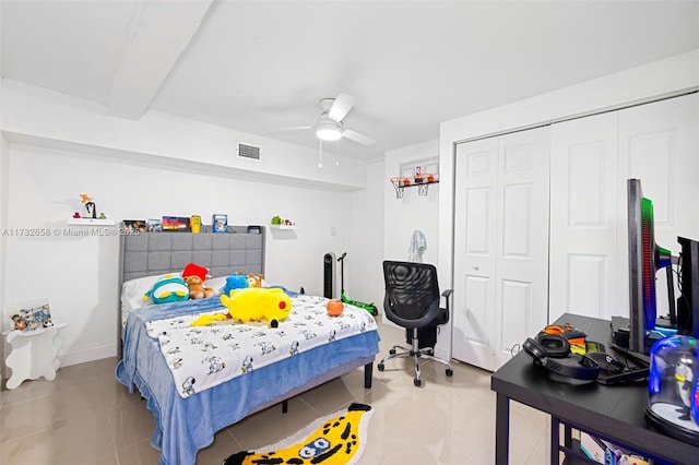 bedroom featuring light tile patterned floors, ceiling fan, and a closet