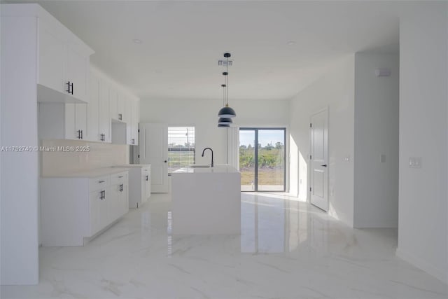 kitchen with white cabinetry, sink, a center island with sink, and pendant lighting