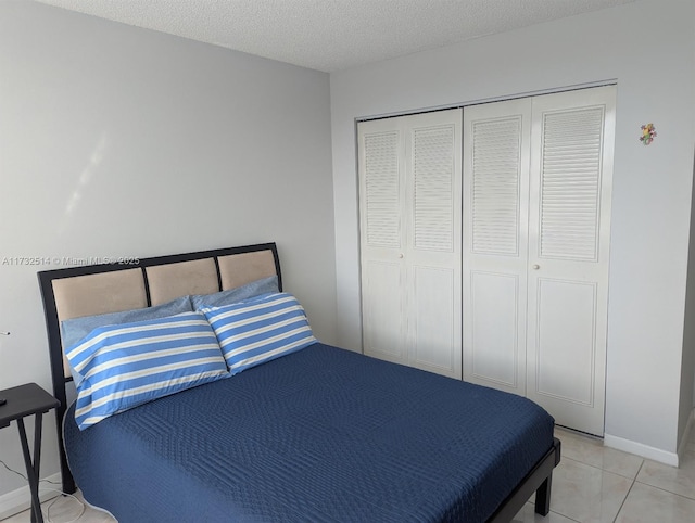 tiled bedroom with a closet and a textured ceiling