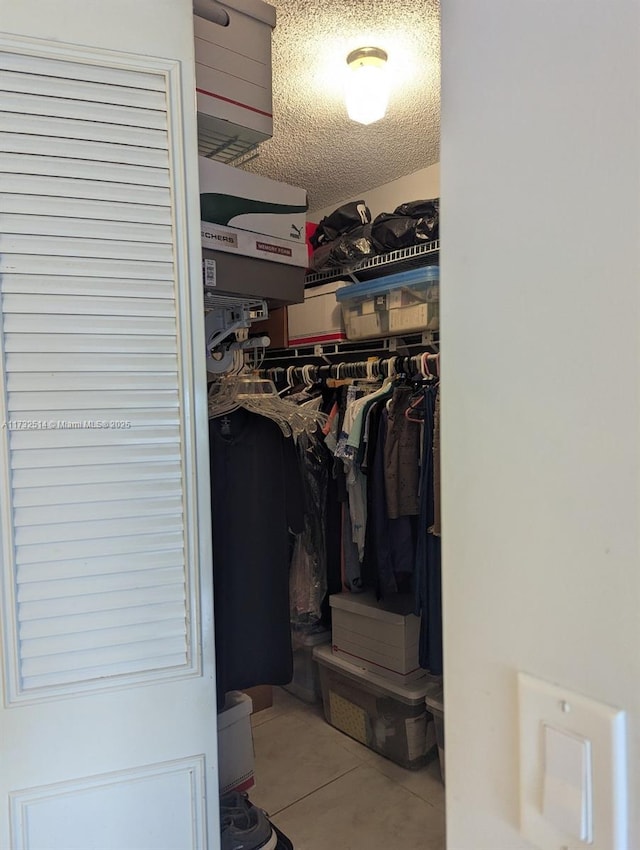 walk in closet with light tile patterned floors