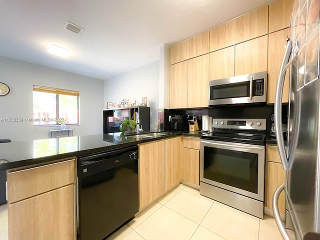 kitchen featuring sink, light tile patterned floors, stainless steel appliances, light brown cabinetry, and kitchen peninsula