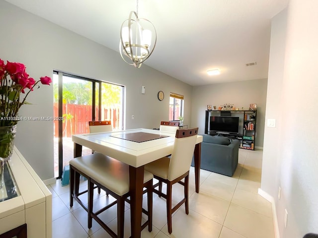 dining room with light tile patterned floors and a chandelier