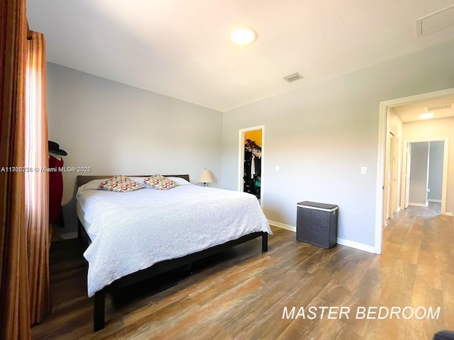 bedroom featuring a spacious closet, hardwood / wood-style floors, and a closet