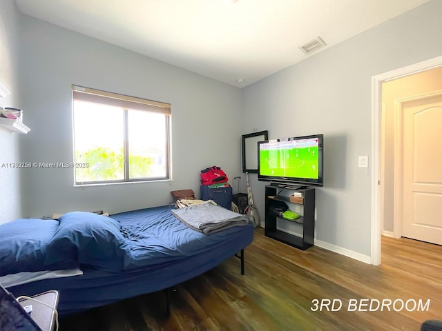 bedroom with hardwood / wood-style flooring