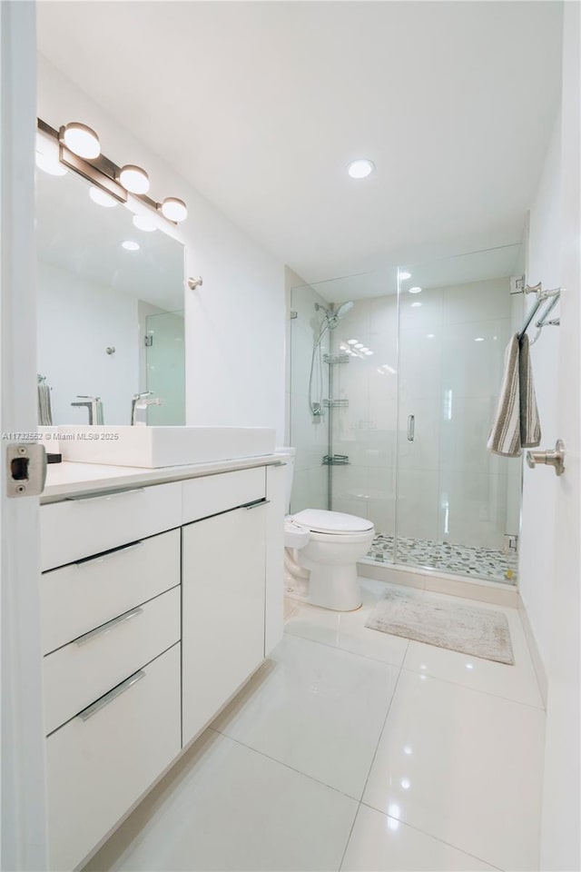 bathroom featuring vanity, tile patterned floors, toilet, and walk in shower