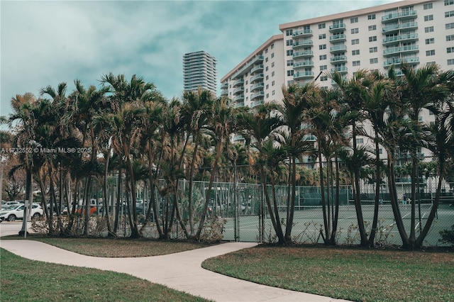 view of tennis court featuring a yard