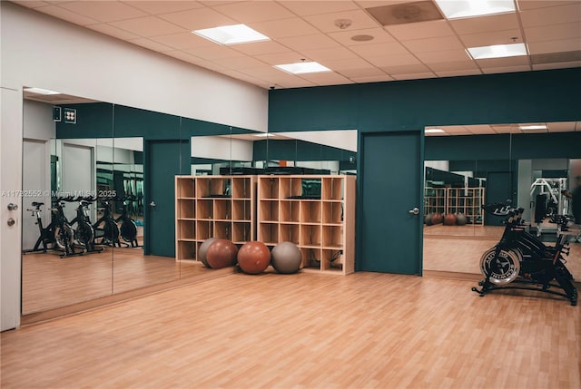 gym with a high ceiling and wood-type flooring