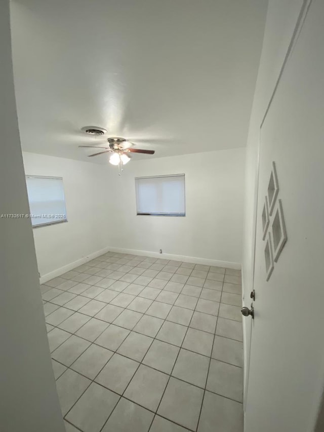 tiled spare room featuring ceiling fan