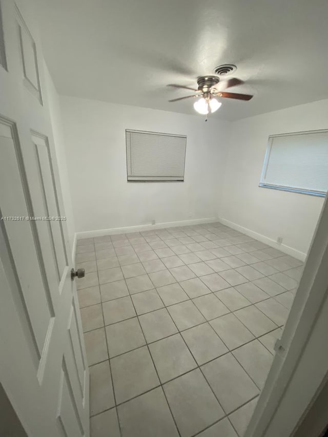 tiled spare room with ceiling fan