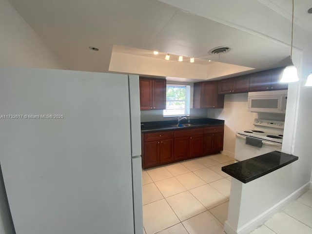 kitchen featuring light tile patterned flooring, white appliances, decorative light fixtures, and sink