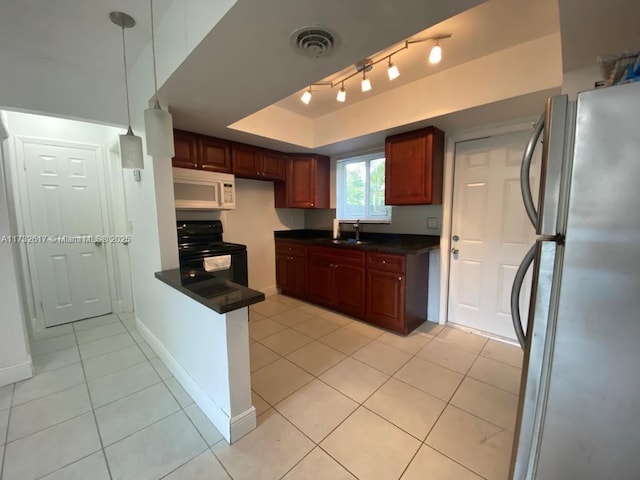 kitchen featuring sink, black / electric stove, a tray ceiling, stainless steel fridge, and pendant lighting