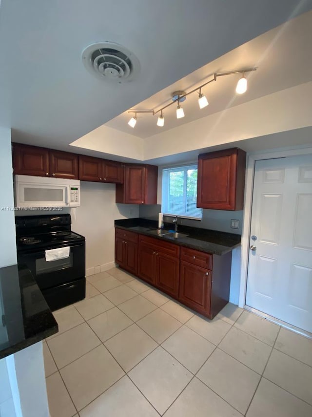 kitchen with light tile patterned flooring, black electric range oven, sink, and a tray ceiling