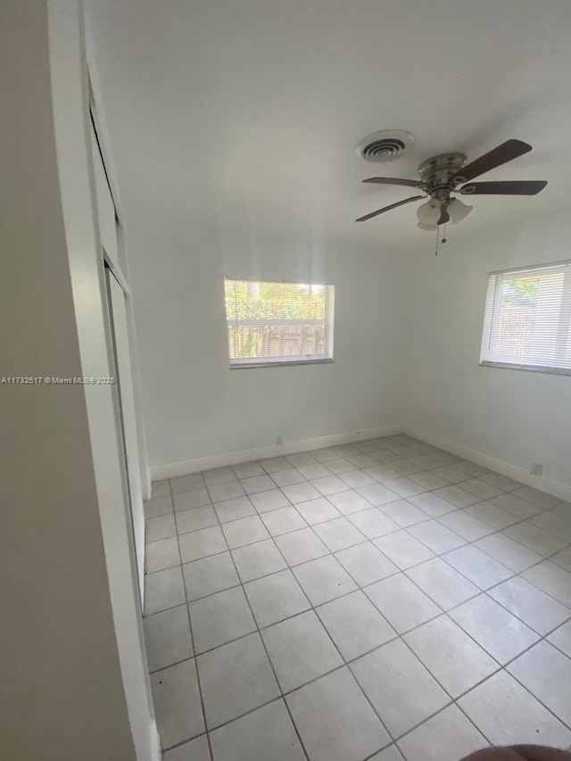 tiled spare room featuring ceiling fan