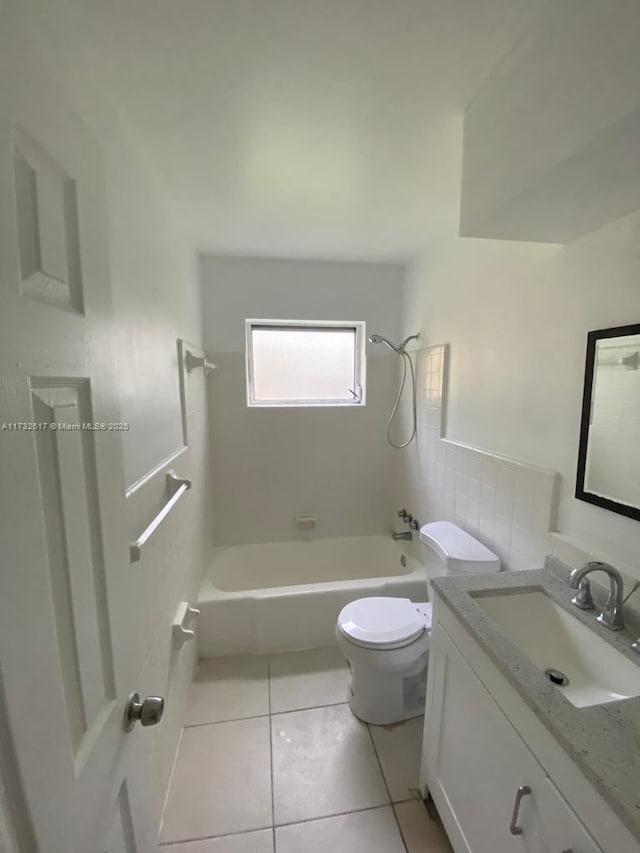 full bathroom with tile patterned floors, toilet, tile walls, vanity, and tiled shower / bath combo