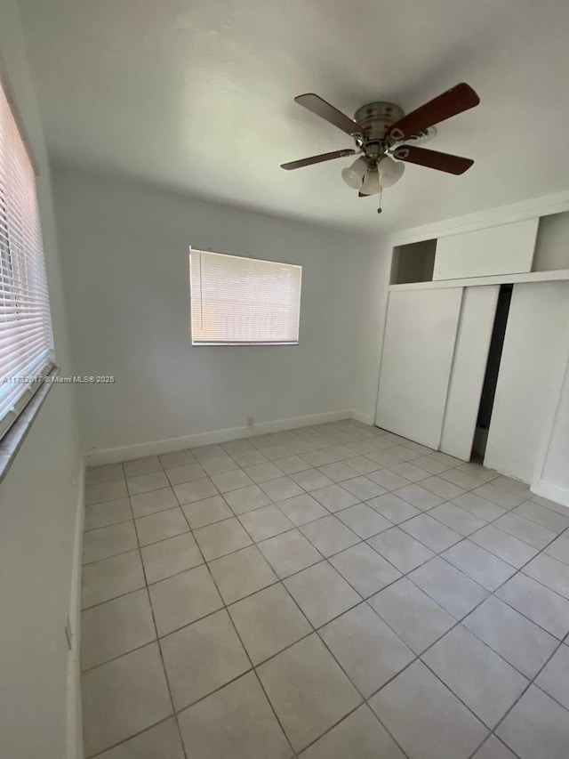 unfurnished bedroom featuring ceiling fan, a closet, and light tile patterned floors