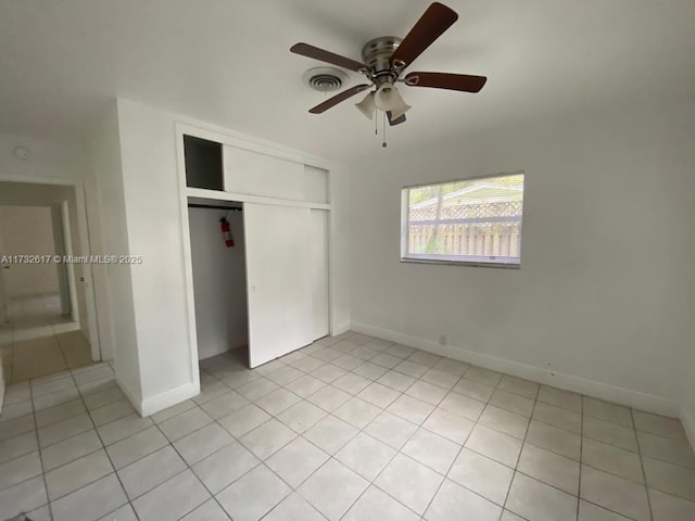 unfurnished bedroom with light tile patterned floors, a closet, and ceiling fan