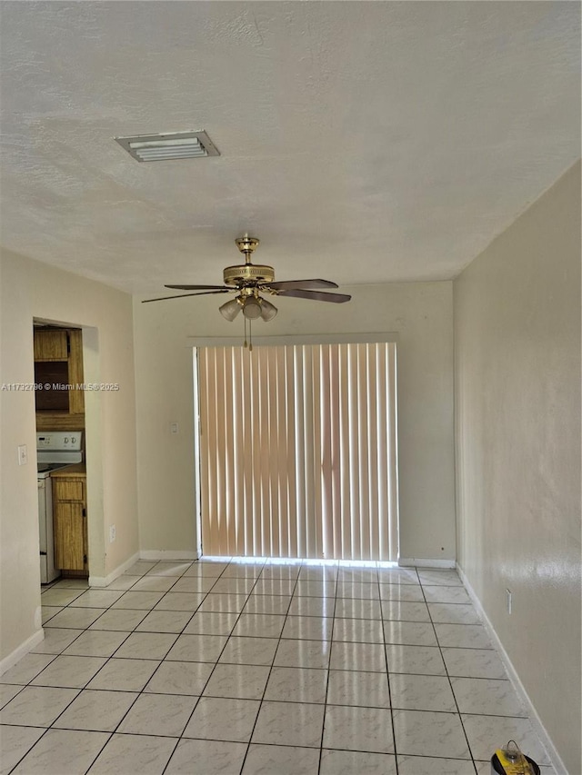 spare room featuring light tile patterned flooring and ceiling fan